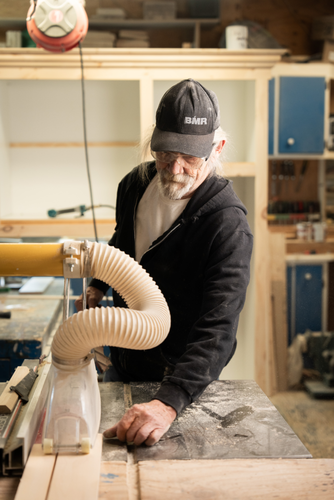 Roland, dans l’atelier de menuiserie de l’organisme communautaire qui l’a soutenu, en train de travailler.